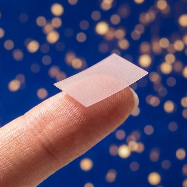 Strawberry-mint dissolvable strip on a fingertip